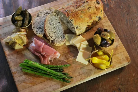 Tagliere con pane, prosciutto, olive e formaggio