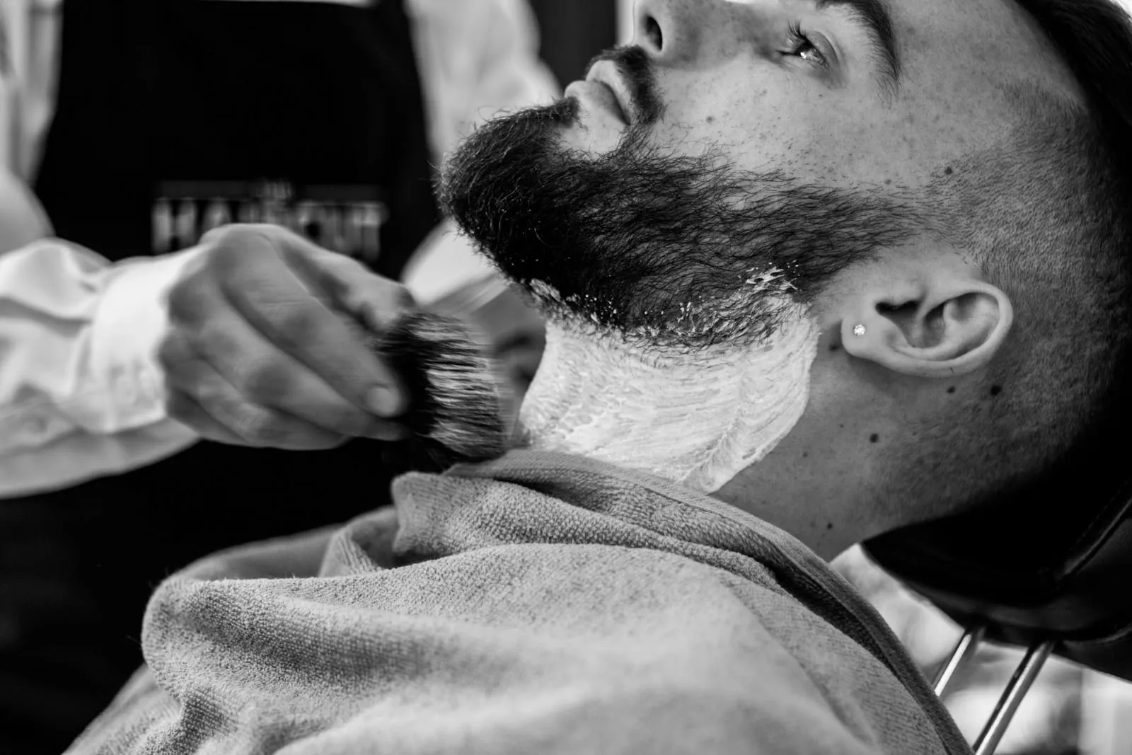 Primo piano in bianco e nero di una barba insaponata con il pennello