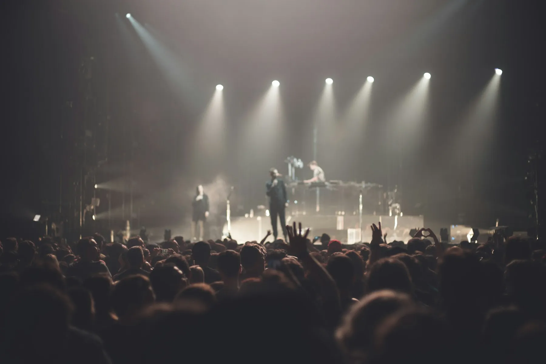 Un palco con luci puntate sul pubblico durante un concerto.